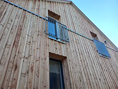 Fenstergitter aus Flachstahl an Holzfassade
